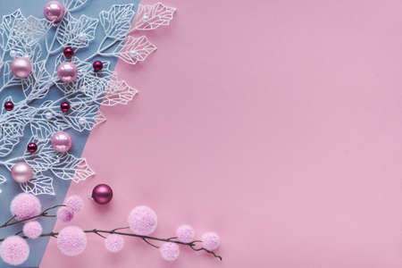 Romantic Christmas flat lay, top view on two color paper background with copy-space. Decorative white winter twigs with frosted geometric leaves and soft textile baubles and scattered glass trinkets.の写真素材