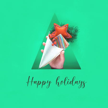 Happy Holidays text. Hand with natural decorations, gift box in craft paper and soft felt handmade...
