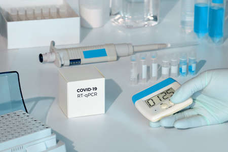 Quick novel COVID-19 coronavirus test kit. 2019 nCoV pcr diagnostics kit. Hand in glove with timer. RT-PCR kit to detect covid19 virus in clinical samples. Ð¢est based on real-time PCR methodology.の写真素材