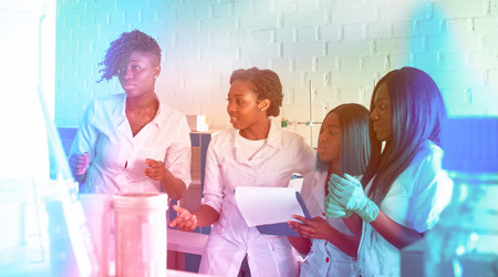 Female African medical students, young graduates in research, medical test lab laughing smiling...