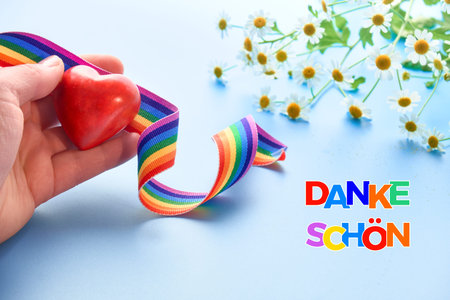 Red heart and rainbow ribbon. Rainbow text Danke shon in German language means Thank you in English....