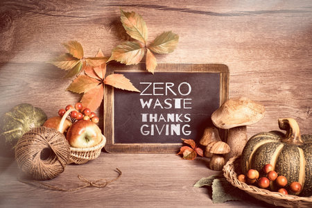 Autumn rustic arrangement with text Zero waste Thanksgiving on a chalk board. Natural Fall...