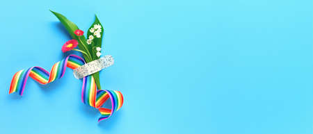 Thank you doctors and nurses! Rainbow ribbon and bouquet of red primrose and lily of the valley flowers attached with medical aid patch. Creative panoramic flat lay, blue mint background, text space.の写真素材