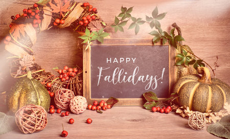 Autumn rustic decorations with text Happy Fallidays on a chalk board. Natural Fall Thanksgiving...