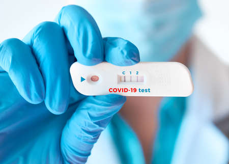 Doctor shows rapid laboratory COVID-19 test for detection of IgM and IgG antibodies to Novel Coronavirus, SARS-CoV-2 with positive result. Immunity against novel pathogen causing worldwide pandemics.の写真素材