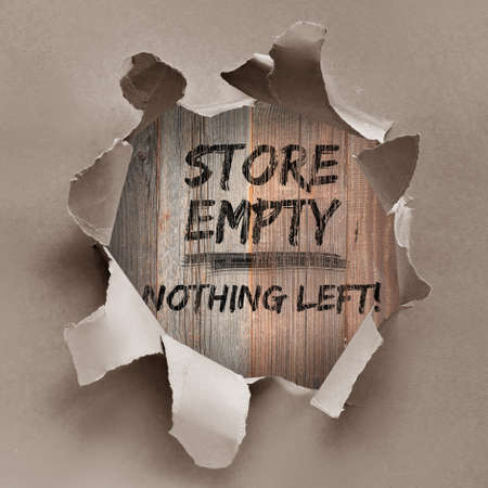 Text "Store empty nothing left" painted black on wooden boards through the hole in wrapping craft paper. Boutique shops, stores boarded up against violence. Aftermath, riots, looting in New York City.の写真素材