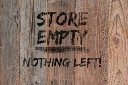 Text "Store empty nothing left" painted black on boarded storefront. Boutique shops and stores boarded up against violence. Aftermath concept with text. Protests, riots and looting in New York City.の写真素材