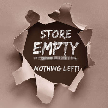 Text Store Empty Nothing Left painted black on wooden boards through hole torn in wrapping craft paper. Boutique shops, stores boarded up against violence. Aftermath, riots, looting in New York City.の写真素材