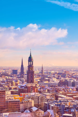 Scenic panorama view from Dancing Towers over Hamburg under snow in winter with St. Michael's Church (German: St. Michaelis) and downtown city skyline at sunset.のeditorial素材