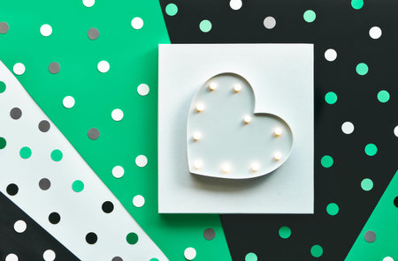 Abstract heart shape banner or card template with confetti, polka dots. Light box on square white...