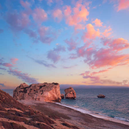 Rock Aphrodite near Petra tou Romiou in Cyprus, Paphos. Panoramic image of famous Cyprus landmark on romantic sunset with pink clouds.の写真素材