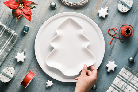Christmas background in grey, red and white. Text space, copy-space on ceramic plate in shape of...