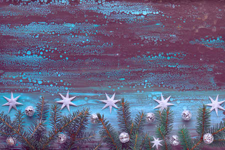 Christmas background in purple, blue and black. Flat lay with fir twigs, mirror disco balls and silver stars on dark blue and black textured board. Panoramic composition, copy-spaceの写真素材