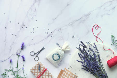 Aromatic dry lavender bags packed in self made eco-friendly gifts. Fresh and dry lavender flowers. Flat lay on white marble.の写真素材