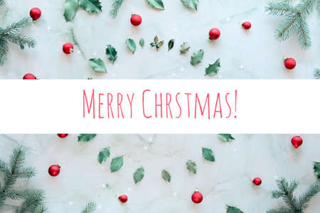 Text Merry Christmas. Marble stone background. Xmas background with natural fir twigs, holly leaves and glass trinketsの写真素材