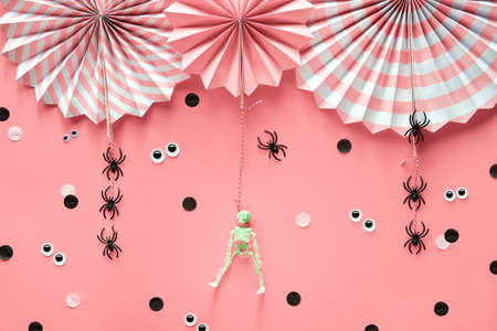 Pink Halloween decorations. Decorative paper fans, spiders, skeleton. Black and white confetti.の写真素材