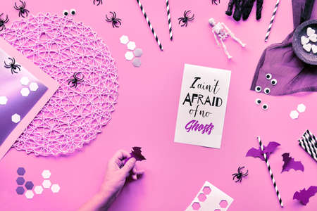 Pink paper top view background with Halloween decor. I aint afraid of no ghosts text on paper.の写真素材