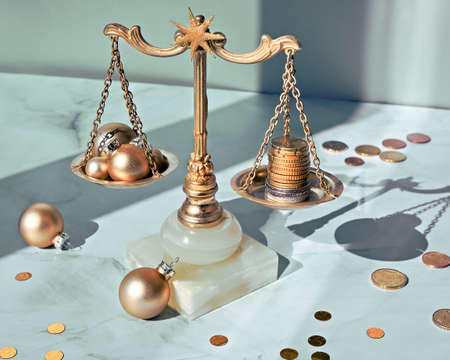 Weight scales, vintage balance with stack of coins and Xmas balls on white marble table.の写真素材