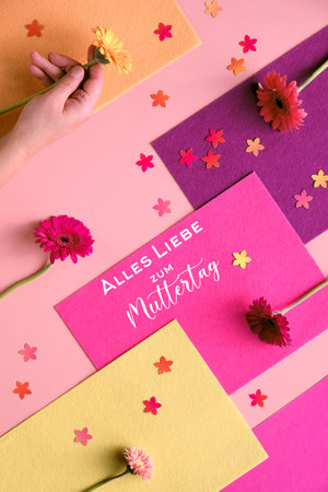 Text Alles Liebe zum Muttertag means Much love for Mothers day. Geometric two tone flat lay on paper...