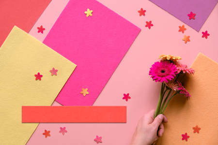 Vibrant flat lay with gerbera daisy flowers on coral color paper. Creative flat lay, toned image. Top view in red, cream and orange.の写真素材