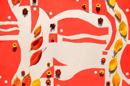 Autum flat lay, paper craft and natural materials. Abstract geometric background in orange, yellow and beige. Organic paper shapes with Fall yellow leaves and small chrysantemum flowers.の写真素材