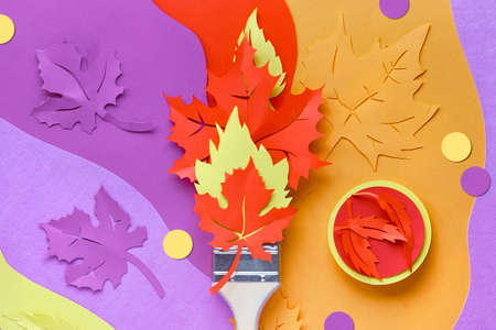Brush loaded with paint made from paper Autumn leaves. Home renovation concept background in red, yellow, orange, purple colors. Creative background, top view, flat lay.の写真素材