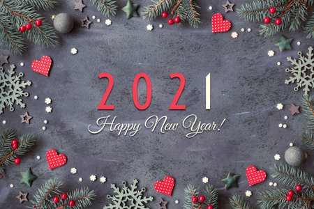 Happy New Year 2021 text. Frame with fir twigs, trinkets in red and green, stars, hearts, berries...