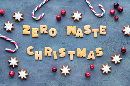 Text Zero Waste Christmas made from cookies. Xmas top view. Minimal design with candy canes, star...