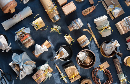 Zero waste Christmas gifts, geometric background on blue linen textile table. Layered mason jar, cups, insulated bottle, bamboo cups and mat, coconut bowls and much more. Eco friendly gifts.の写真素材