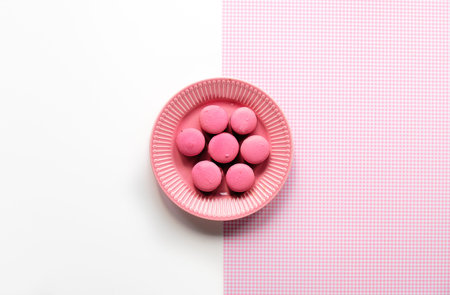 Pink macaroons on a plate. Simple monochrome flat lay on split two tone pink white background....