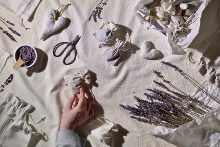 Hand made lavender sachets in textile bags, soft hearts. Hand hold sachet. Dry lavender flowers for stuffing. Packed craft gift box. Zero waste, low impact lifestyle. Flat lay, textile tableclothの写真素材