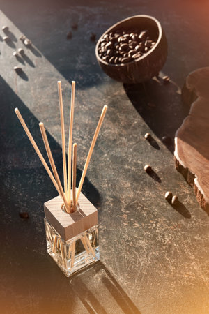 Air freshener with bamboo sticks with perfume in glass on dark textured background.Invigorating...