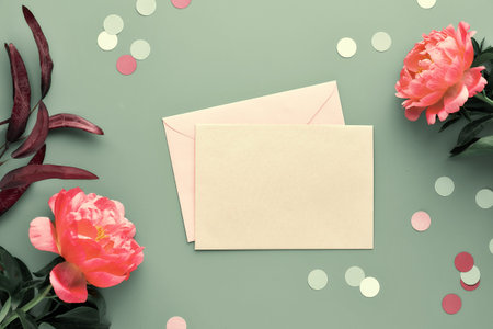 Greeting card design with pink peony flowers on faded green background, text space on paper card....
