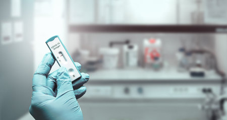 Hand in glove hold express  antigen test to check for infection. Laboratory interior out of focus....