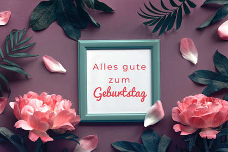 Birthday card with peony flowers in moody jungle green and red. Text Aller gute zum Geburtstag meand Happy Birthday in German. Text in wooden frame. Flat lay floral design for greeting card.の写真素材