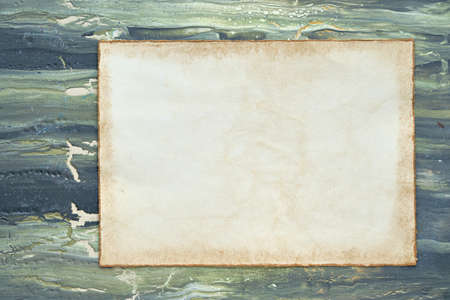 Mockup, copy-space on aged patchment, beige paper page. Flat lay on aged textured painted green brown background. Abstract textured background.の写真素材