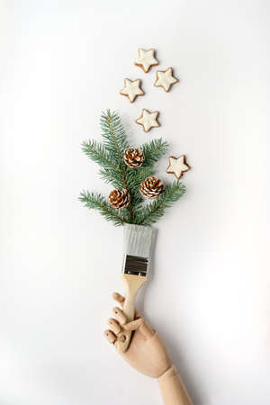 Old porcelain cup in hands with pale yellow wild flowers. Aged crackled paint, flat lay on textured light mint green background. Mature female hands hold cup.の写真素材
