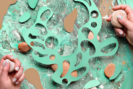 Abstract natural background, wild flowers and natural stones in hands. Abstract organic shapes cut...