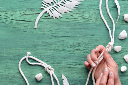 Abstract grungy mint green wooden background with exotic paper leaves made of paper and white...
