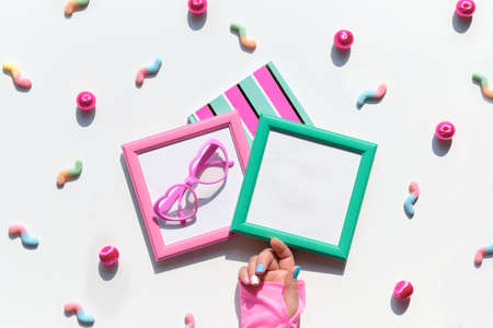sweets, chocolate, candy, sweet food in hand. Various tasty snacks in pastel colors, pink, mint green, on white background. Text in pink square frame.の写真素材