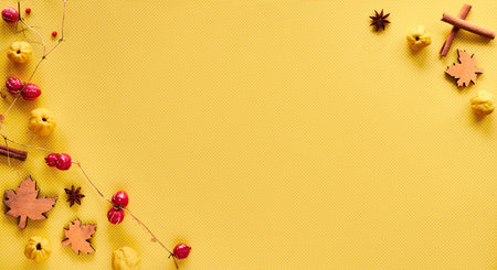 Autumn decorations on yellow paper with copy-space. Quince fruits, natural garland, wooden deco...