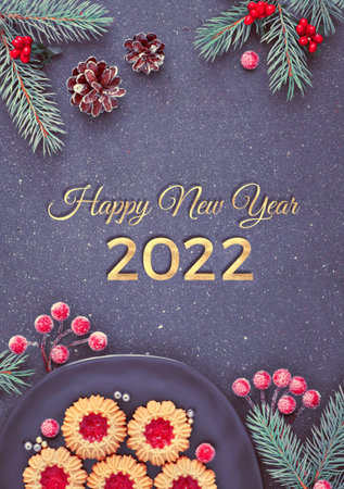 Flat lay with Xmas decorations in green and red and jam cookies on dark table. Text Happy New Year...
