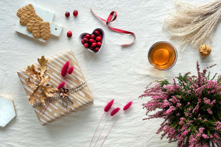 Autumn decorations - heather, cranberry, cookies. tea and dry leaves.の写真素材