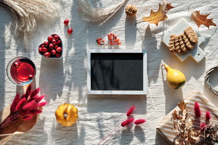 Blackboard mockup. Autumn decorations - cranberry, cookies. tea and dry oak leaves.