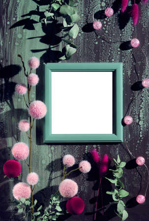 Soft, fluffy Christmas decorations on dark abstract background. Green eucalyptus twigs, pink and dark magenta fluffy balls, bunny tail grass. Sunlight with shadows. Copy-space in frame.の写真素材