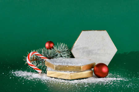 Marble hexagon podium with winter Christmas holiday decor. Red white baubles, berries on fir twigs, candy cane.の写真素材