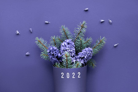 Winter bouquet on purple very peri monochrome paper background. Simple minimal winter arrangement...