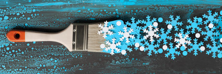 Winter background in blue and white with painting brush loaded with paper snowflakesPanoramic winter...