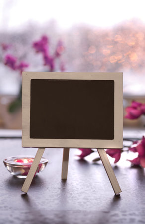 Greeting card mockup, copy-space on blackboard, chalk board. Small decorative black board with pink...