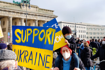 Banner with text Support Ukraine. People with yellow blue flags and posters protest against the war...